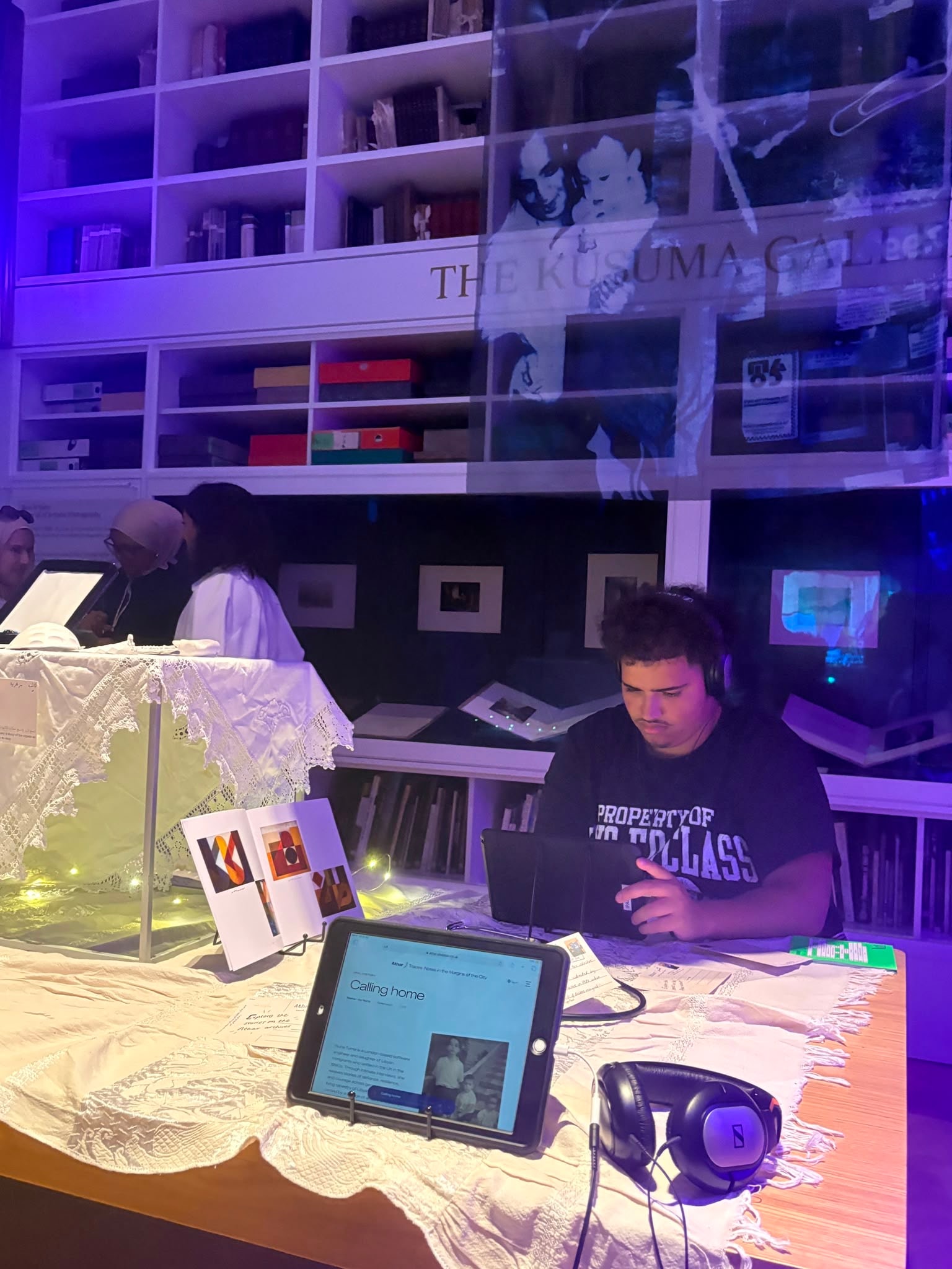 A visitor using a tablet and headphones at the Athar exhibition display.